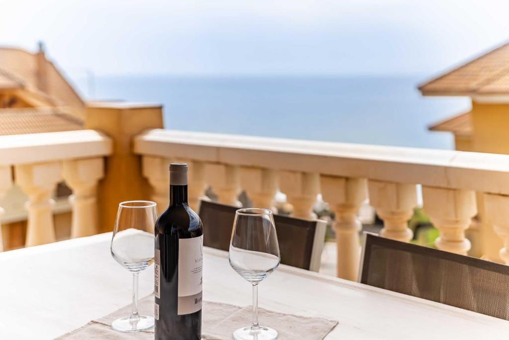 uma garrafa de vinho e dois copos de vinho numa mesa em Casa Annelise em Fuengirola