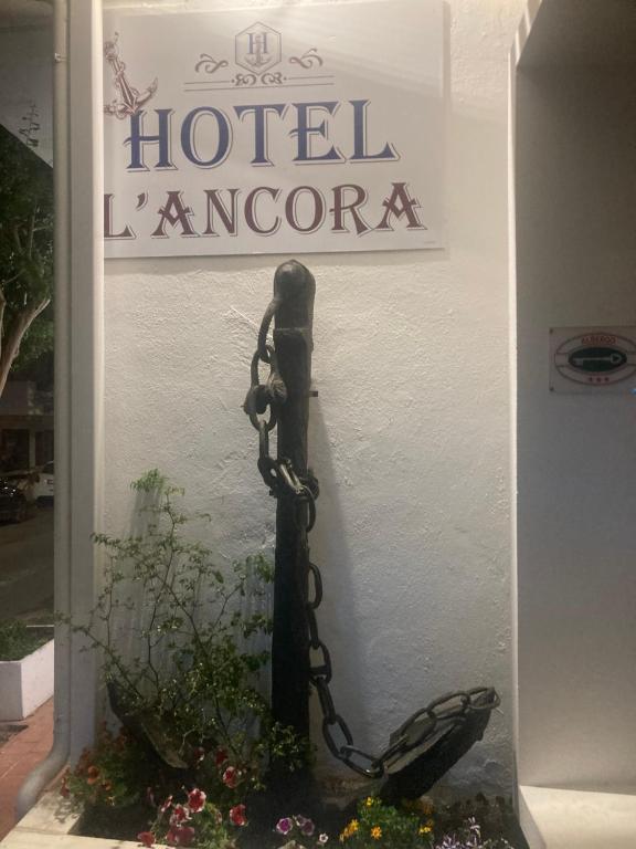 a sign for a hotel karamore with a chain at Hotel L'Ancora in La Caletta