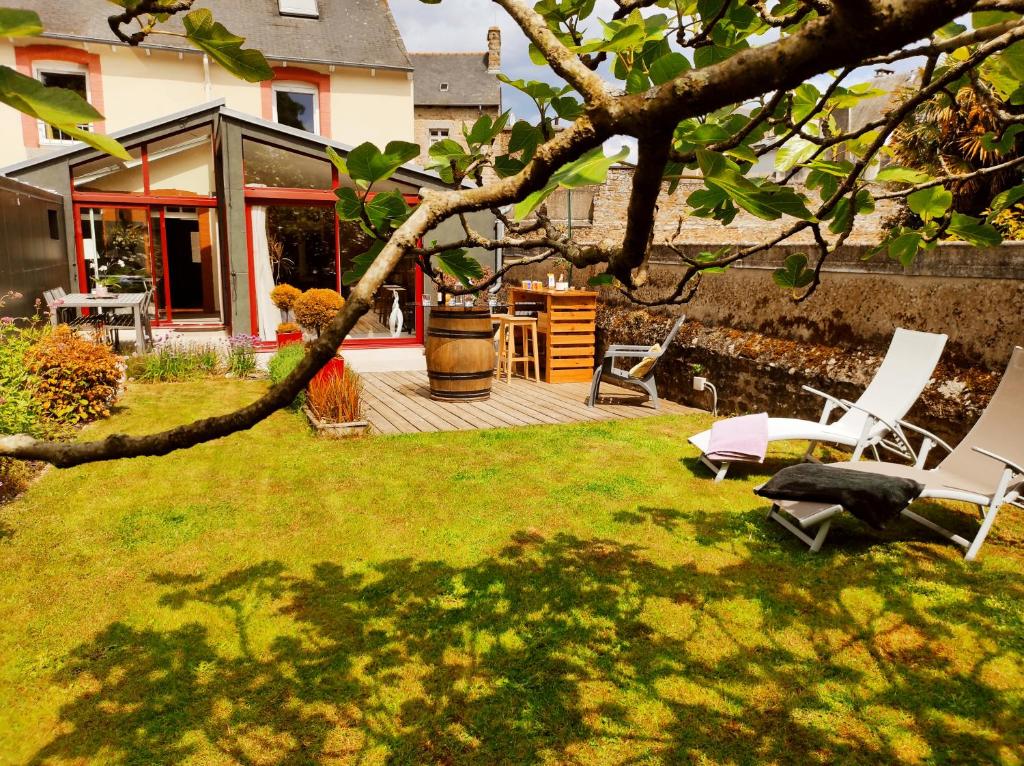 聖布里厄的住宿－Aux Trois Palmiers，一个带躺椅和房屋的庭院