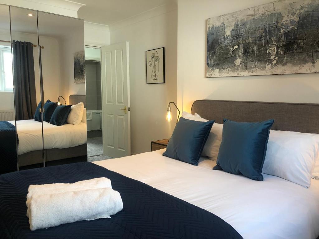una camera con 2 letti con cuscini blu e bianchi di 2 Bedroom Apartment in Central Windsor a Windsor