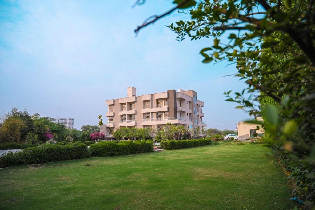 a large building with a grassy yard in front of it at The Govindam Resort in Vrindāvan
