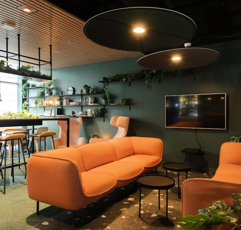 a living room with an orange couch and a bar at Citybox Bergen Danmarksplass in Bergen