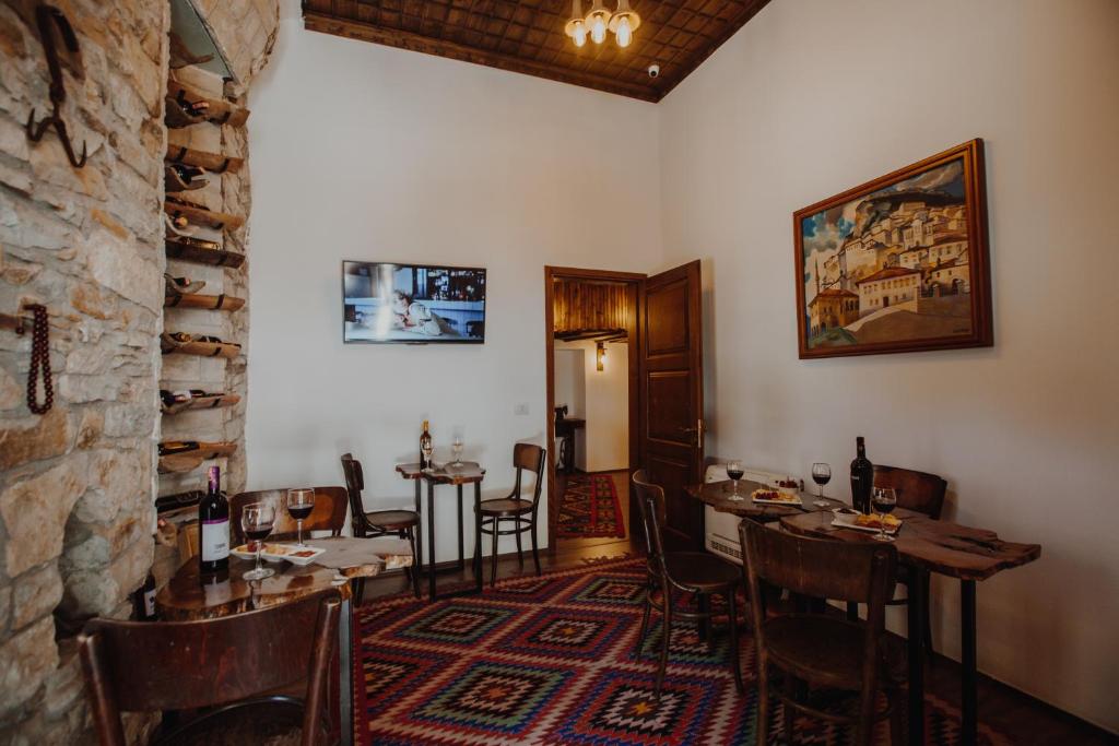 a dining room with tables and chairs and a stone wall at Tradita e Beratit in Berat