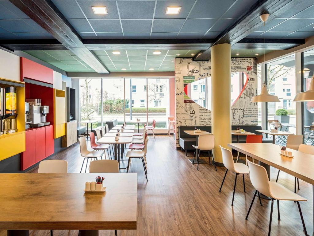 a restaurant with tables and chairs in a room at ibis München Parkstadt Schwabing in Munich