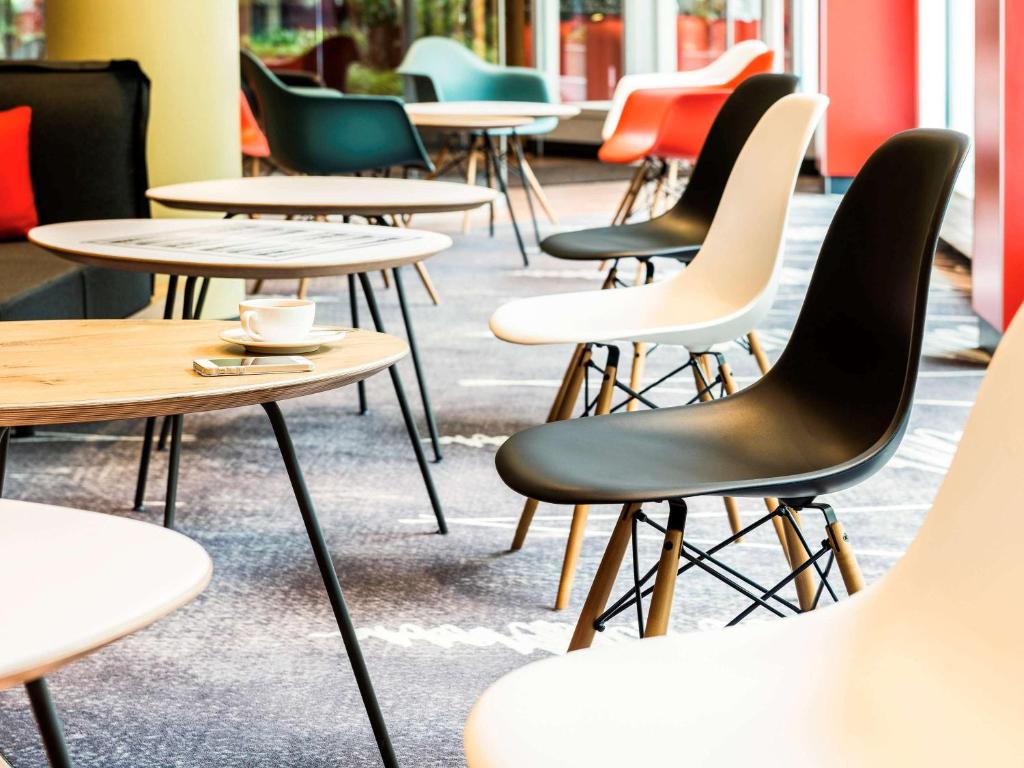a row of tables and chairs in a restaurant at ibis München Parkstadt Schwabing in Munich