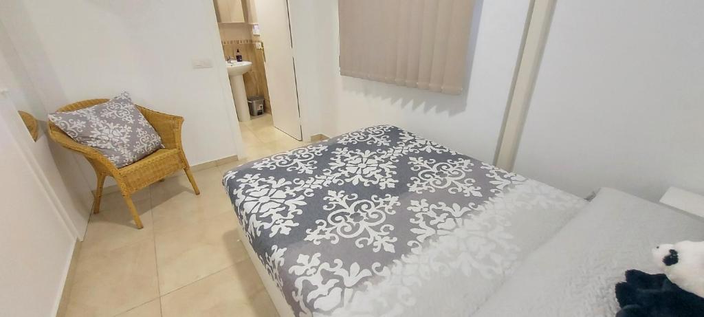 a bedroom with a bed with a gray and white blanket at LAS 7 ISLAS, BARRANCO DE ADEJE in Adeje