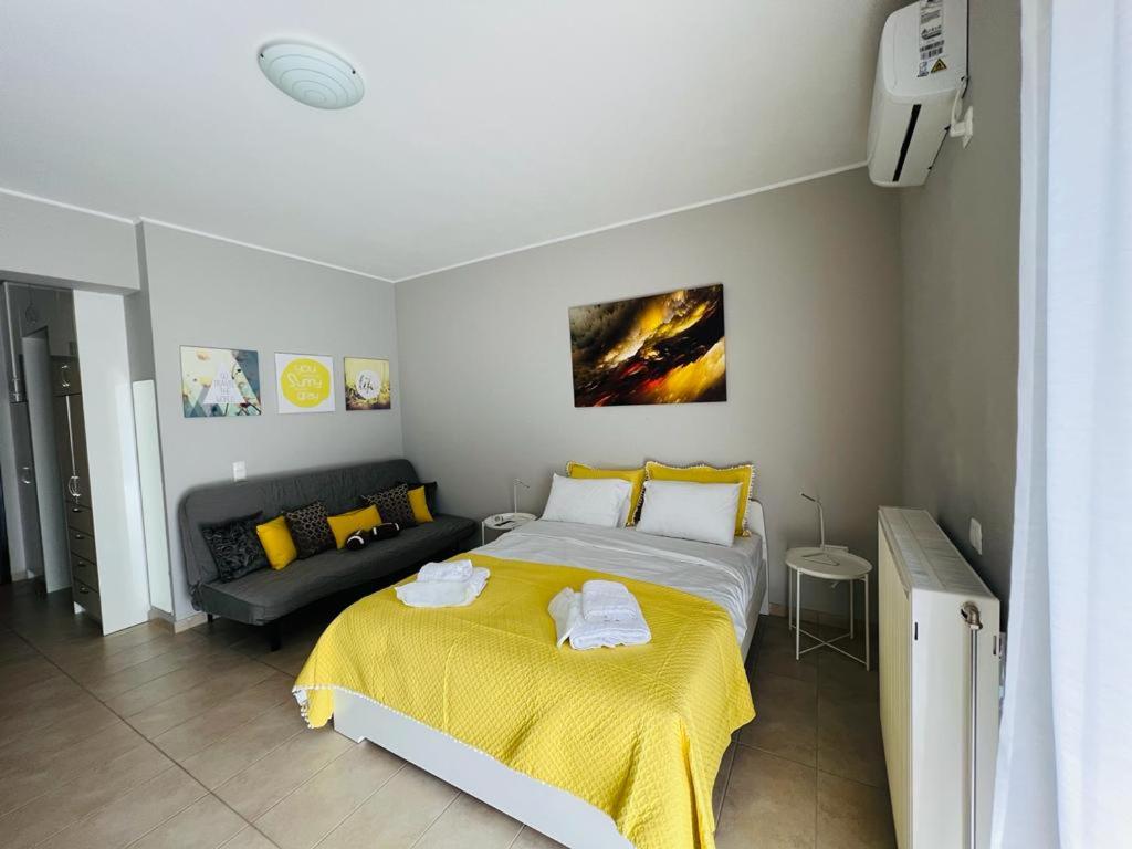ein Schlafzimmer mit einem großen Bett und einem Sofa in der Unterkunft Sunlight studio in Athen