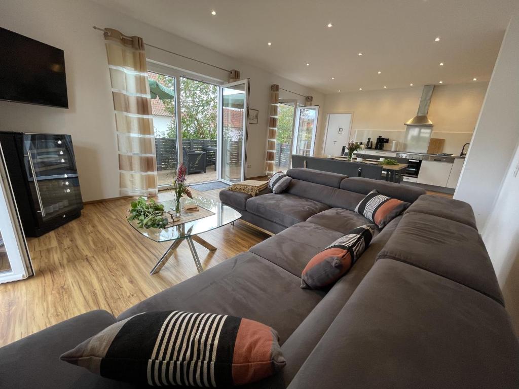 a living room with a large couch and a kitchen at Ferienwohnungen Scheuring Fewo Fritz in Volkach