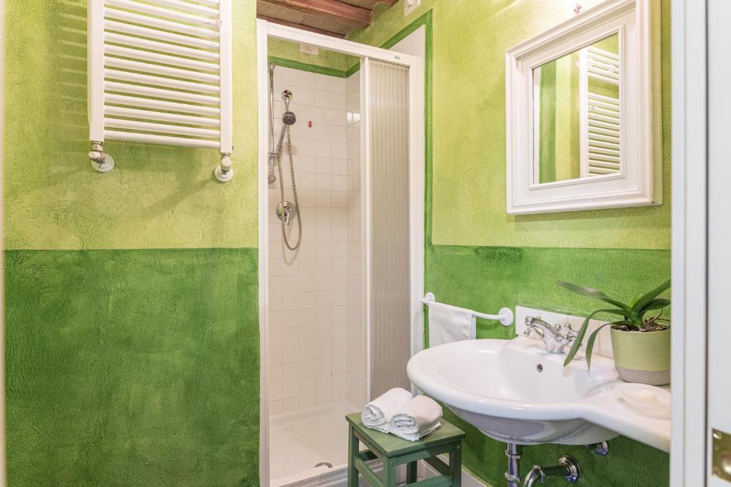 une salle de bain verte avec un lavabo et une fenêtre dans l'établissement PODERE PRATOVECCHIO 14&2, Emma Villas, à Montefollonico