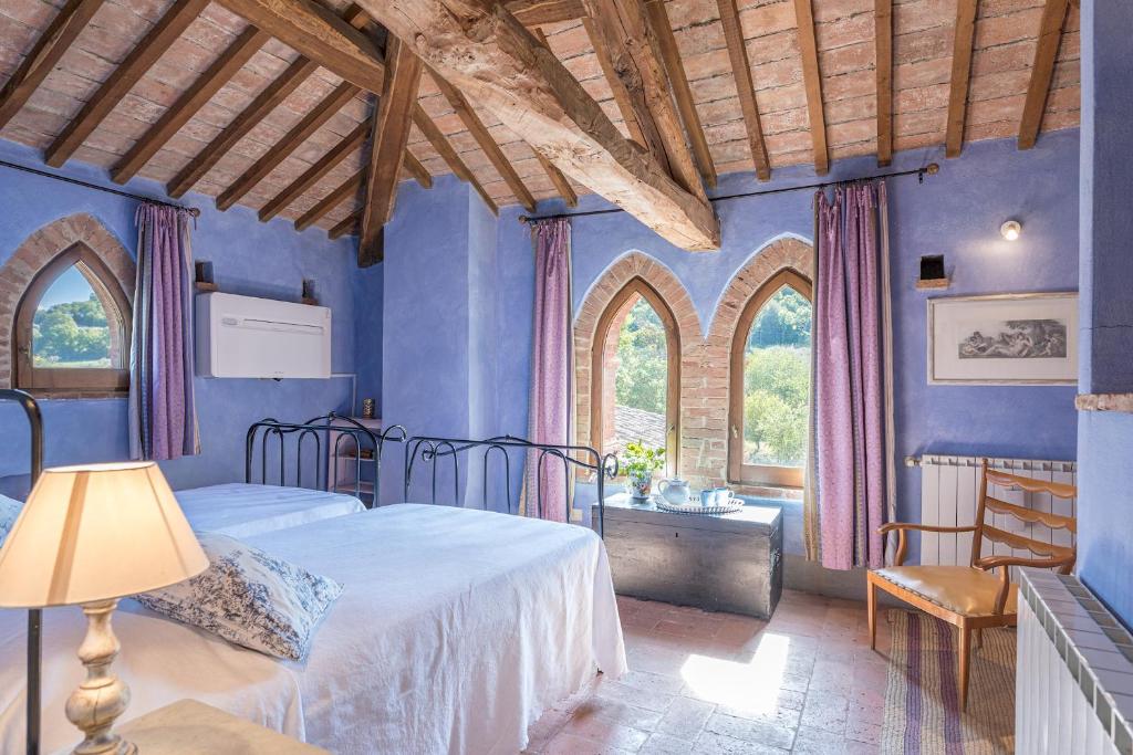 une chambre avec des murs bleus et un lit et une fenêtre dans l'établissement PODERE PRATOVECCHIO 14&2, Emma Villas, à Montefollonico