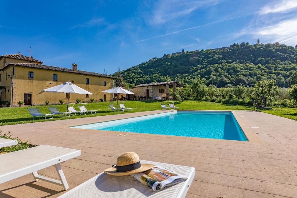 - un chapeau assis sur une table à côté d'une piscine dans l'établissement PODERE PRATOVECCHIO 14&2, Emma Villas, à Montefollonico
