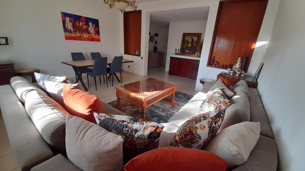 uma sala de estar com um sofá e uma mesa em Adarissa House em Rabat