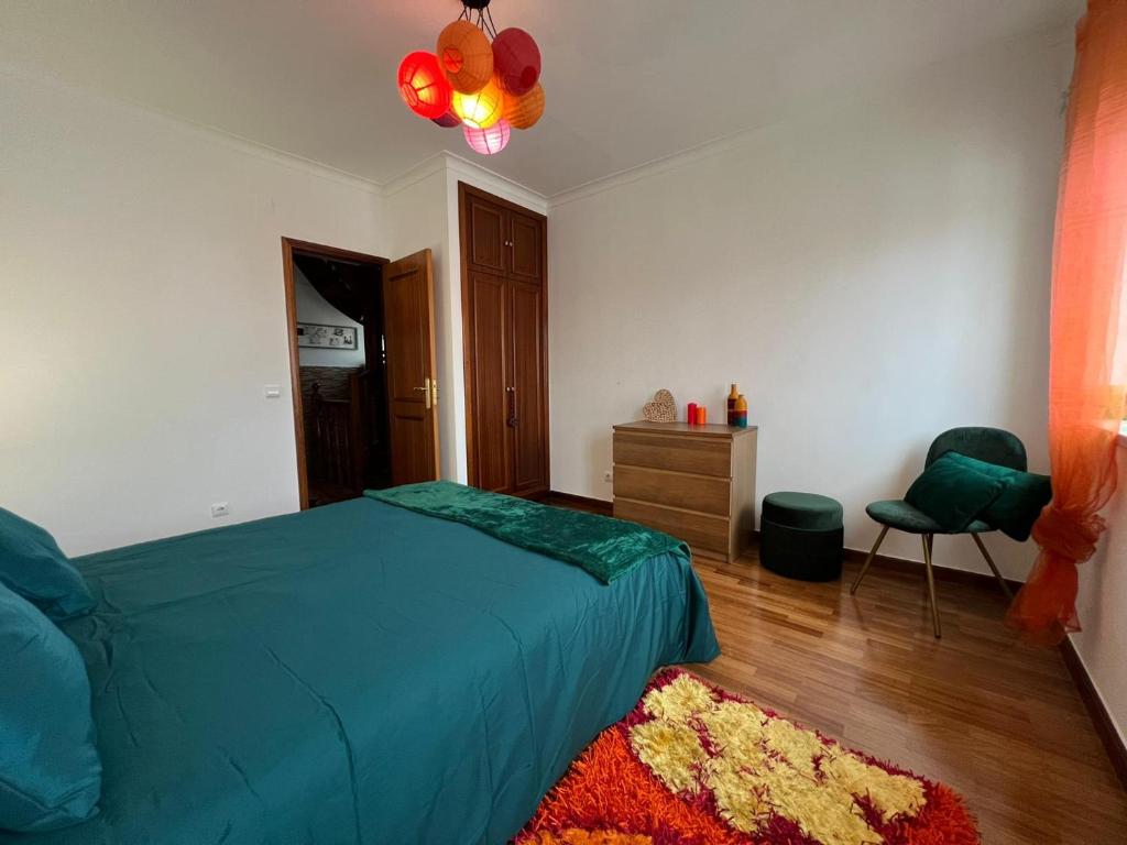 1 dormitorio con 1 cama, 1 silla y 1 alfombra en Amarelaje, en Serra d'El-Rei