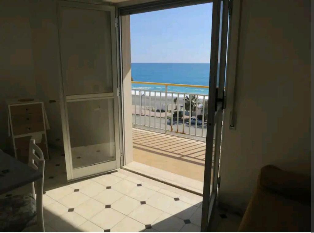 una puerta a un balcón con vistas al océano en Appartamento con vista sul mare, en Marina di Gioiosa Ionica
