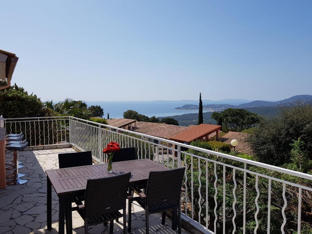 a table with a vase of flowers on a balcony at Villa mit großartigem Panoramablick auf das Meer und direkt am Pool in La Croix-Valmer