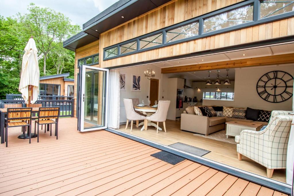 an open deck with a living room and dining room at High Oaks Grange - Contemporary Lodges in Pickering