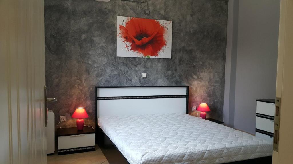 a bedroom with a bed with a red flower on the wall at HOPE HOUSE in Kavála