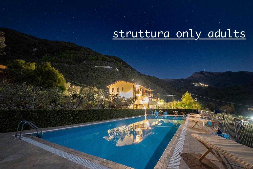 une villa avec une piscine la nuit dans l'établissement Podere Sotto il cielo di Toscana casa vacanze con 5 monolocali indipendenti 2 bungalowe nell uliveto piscina parcheggio Only adults Pet friendly, à Camaiore