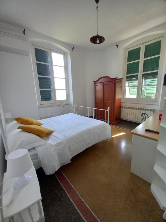 Schlafzimmer mit einem Bett mit weißer Bettwäsche und Fenstern in der Unterkunft La Locanda di San Biagio in Bolzaneto