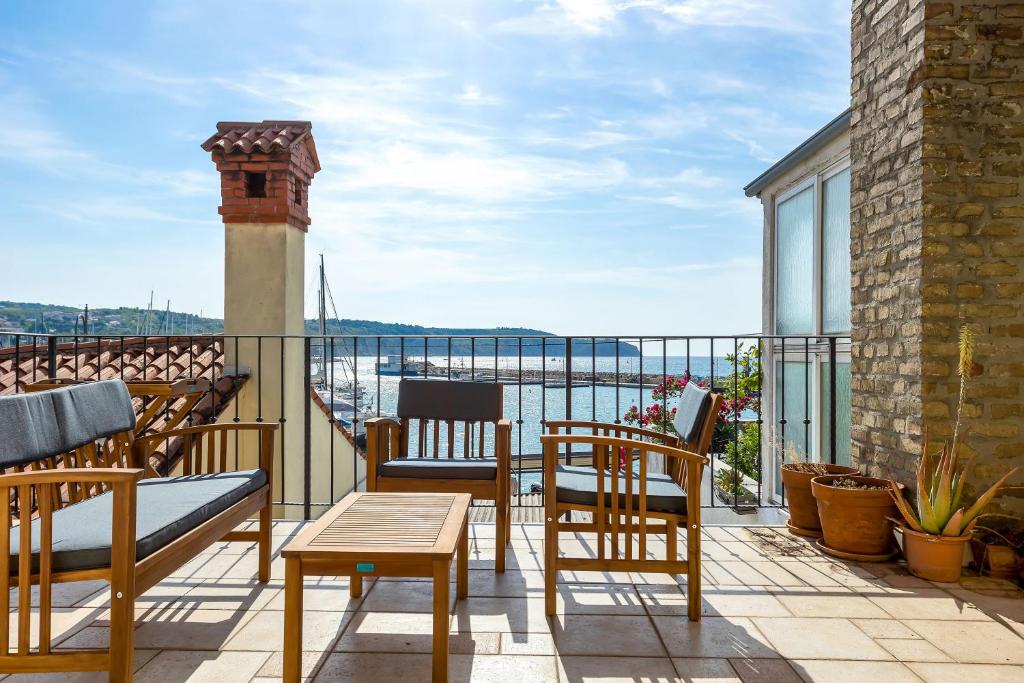balcón con sillas y vistas al agua en Vila Adriana en Izola