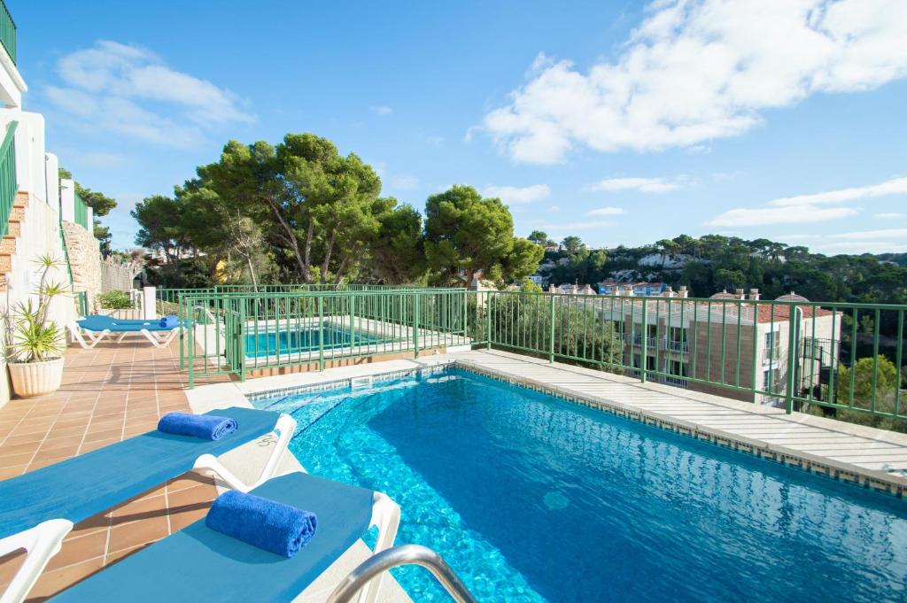 una piscina con 2 tumbonas junto a un edificio en Casa Lluís by Sonne Villas en Cala Galdana