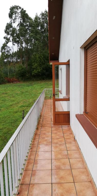 a balcony with a wooden door and a window at Casa Herbellas in Cedeira