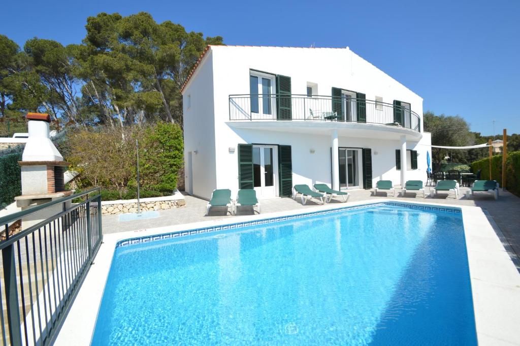 a villa with a swimming pool in front of a house at Villa Azucena by Sonne Villas in Cala Galdana