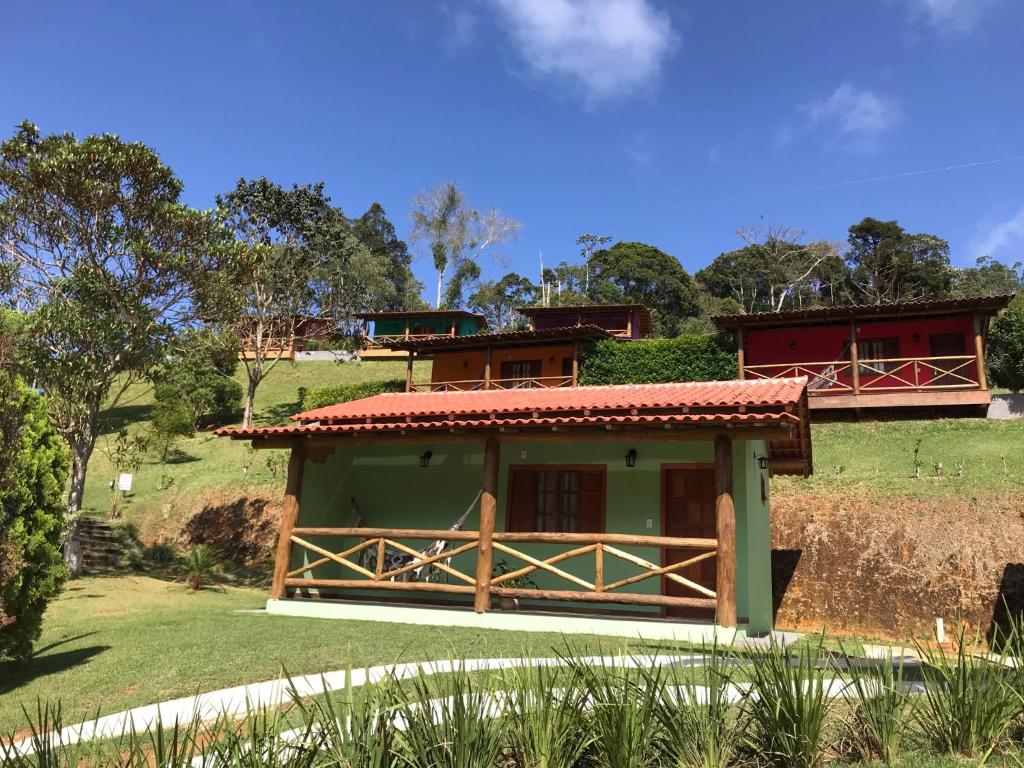 una piccola casa con una recinzione accanto a un campo di Recanto da Roca a Domingos Martins