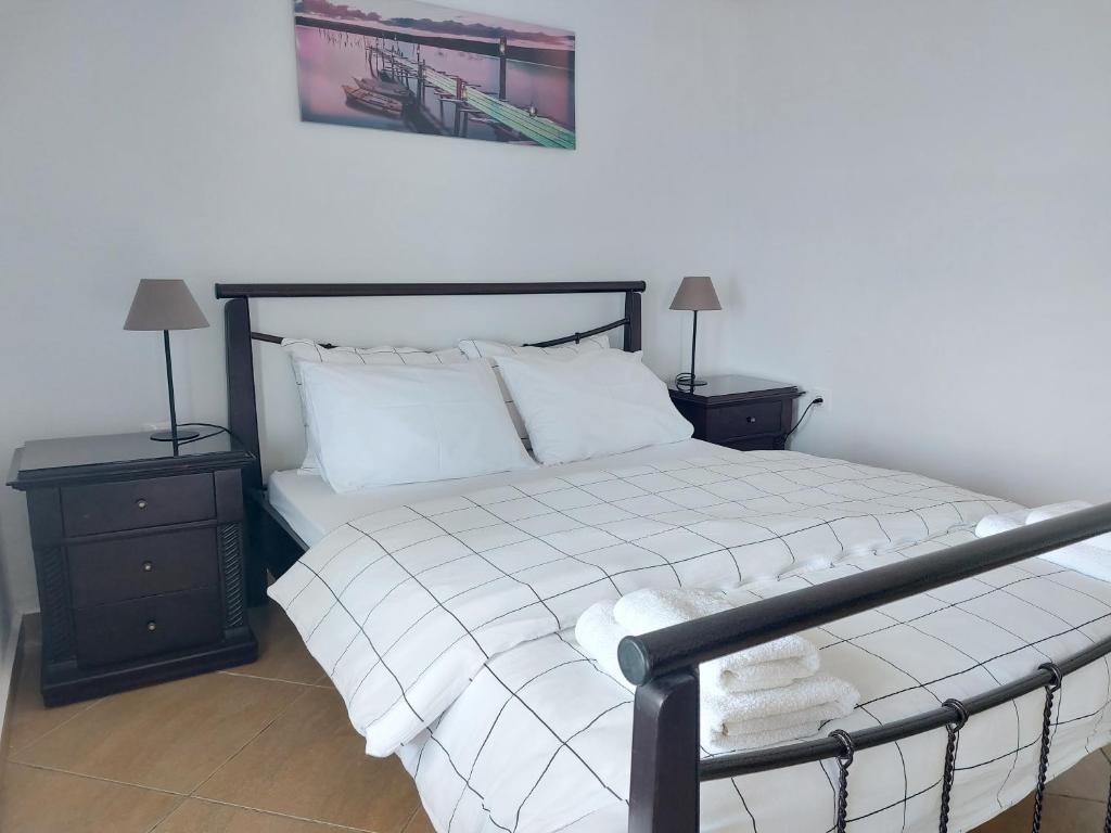 ein Schlafzimmer mit einem Bett mit zwei Nachttischen und zwei Lampen in der Unterkunft Blue View in Qeparo