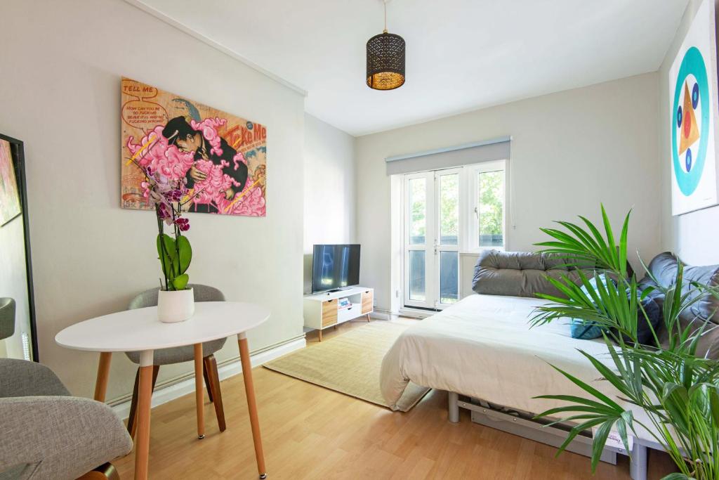 a bedroom with a bed and a table with plants at One bedroom apartment in London