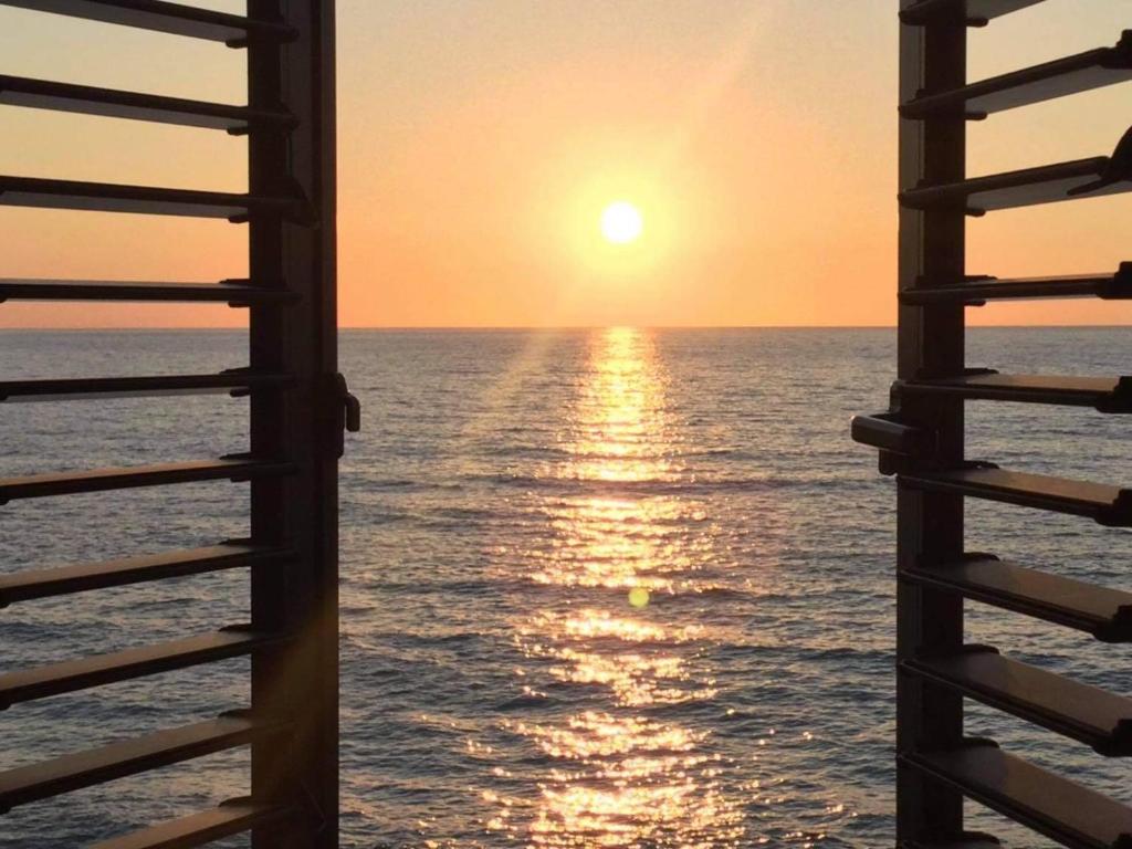 a view of the ocean from a pier at sunset at Shambala Beach House-where mountains meet the sea in Pomos