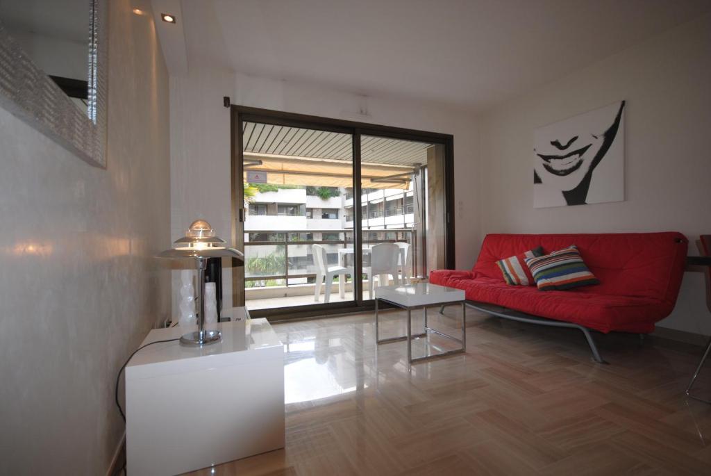un salon avec un canapé rouge et une table dans l'établissement Résidence Gray d'Albion 2P NAP558, à Cannes