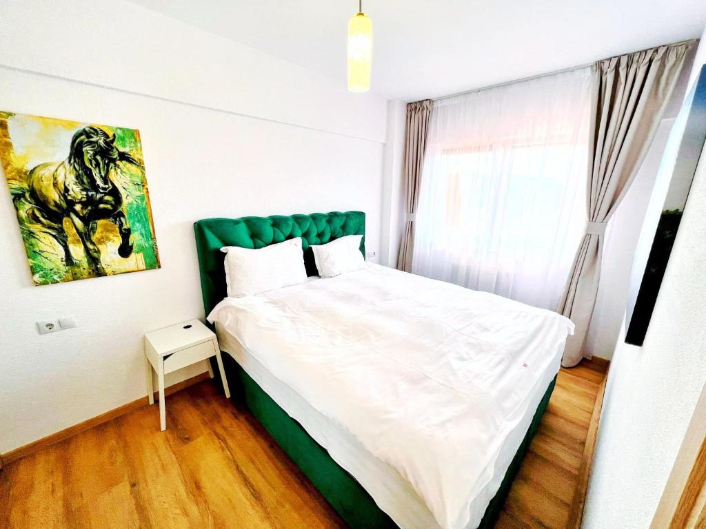 クルジュ・ナポカにあるBusiness Apartmentsのベッドルーム1室(緑のヘッドボード付きのベッド1台付)