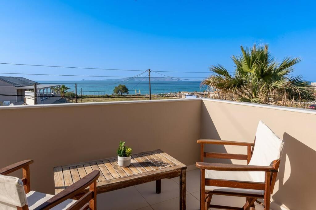 una mesa y sillas en un balcón con vistas al océano en Casa di Brillanti, 2min from the beach! en Karteros