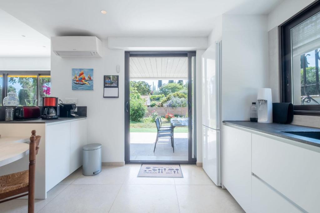 a kitchen with a door leading to a patio at SERRENDY Calm family house with swimming pool in Antibes