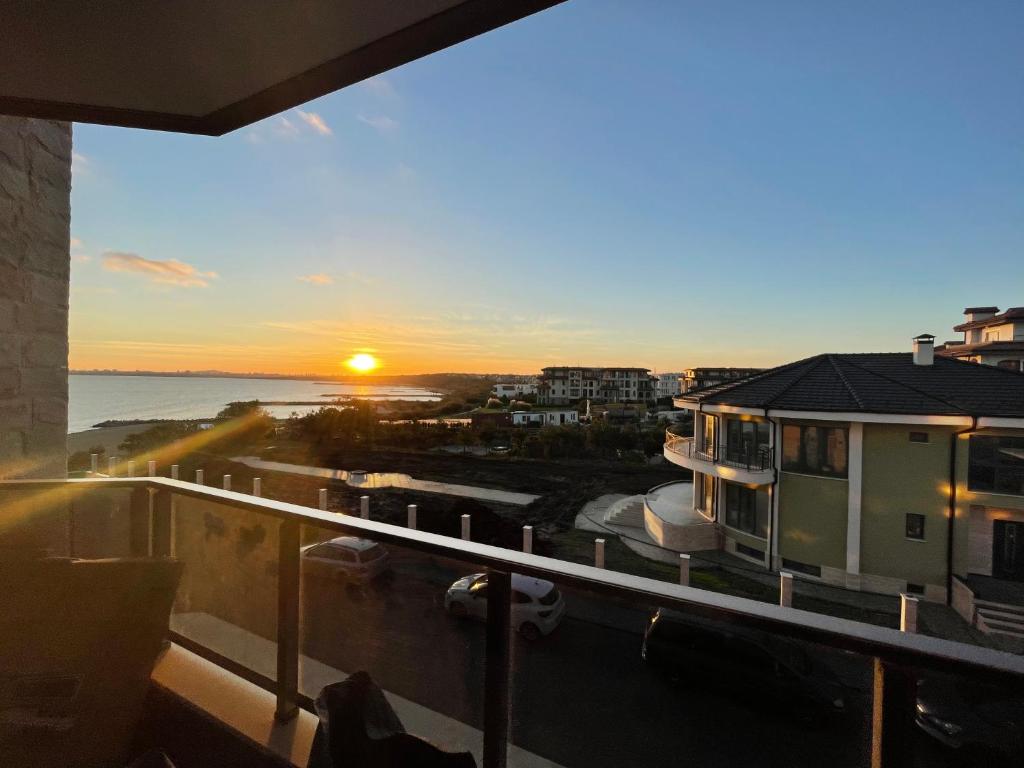 a view of the sunset from the balcony of a building at Brand new first line Sea view 1 bedroom apartment in Burgas City