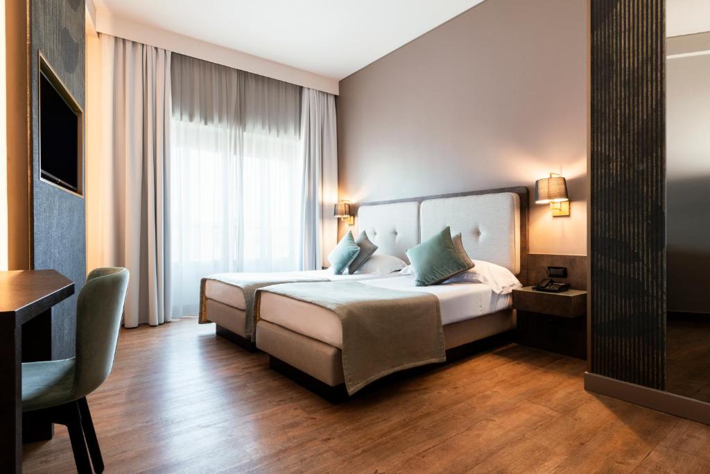 a hotel room with a bed and a desk at Mokinba Hotels King in Milan