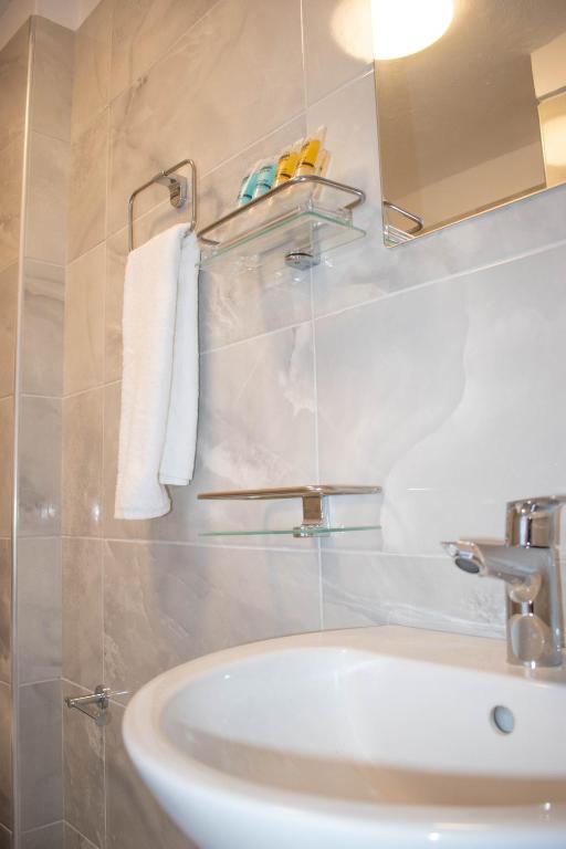 a bathroom with a sink and a mirror at Marea Apartments in Symi