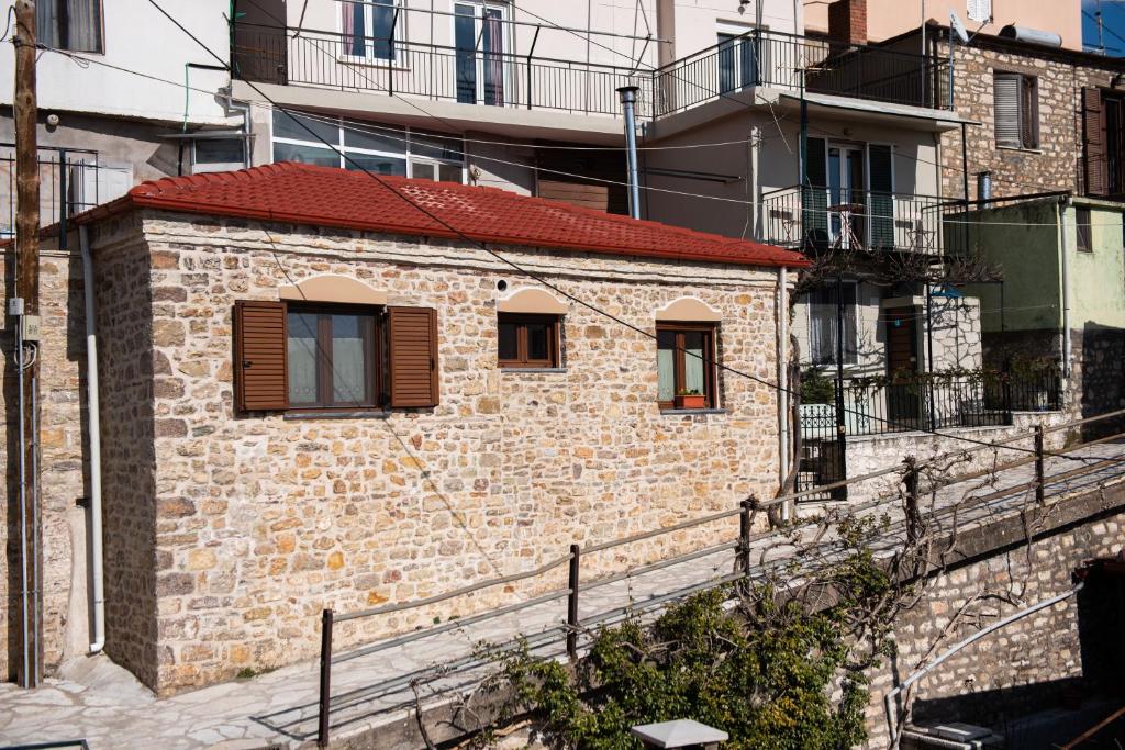 um pequeno edifício de tijolos com telhado vermelho em Το Πέτρινο της Γιαγιάς Μαρίκας em Karpenision