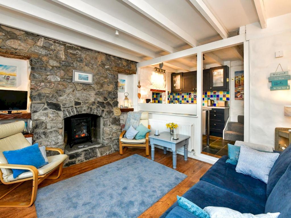 ein Wohnzimmer mit einer Steinmauer in der Unterkunft Pass the Keys Charming Fisherman's cottage with stunning sea views in Swansea