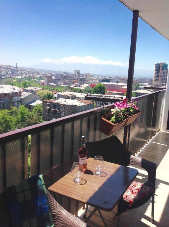 a table with two wine glasses on a balcony at Lily`s Loft in Yerevan