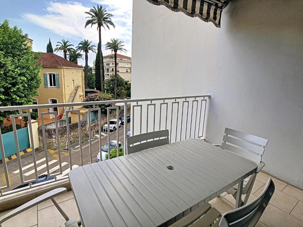d'une table et de chaises sur un balcon avec vue sur la rue. dans l'établissement Le Windsor 2P DET2002, à Cannes