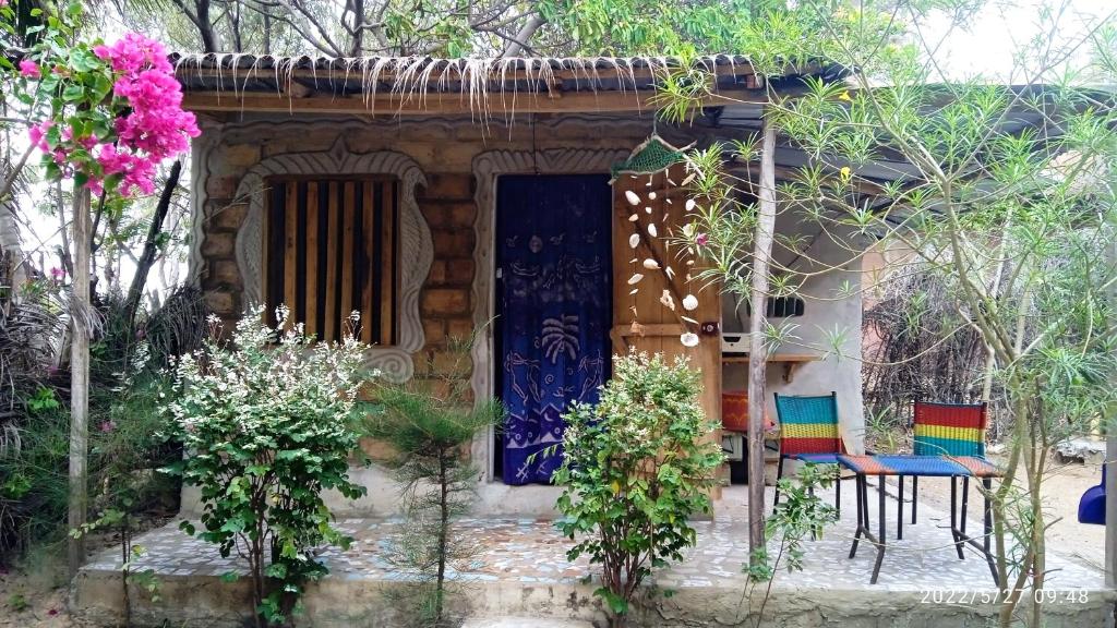 Abémé的住宿－Chez Bethy Jungle et Océan，前面有五颜六色椅子的小房子