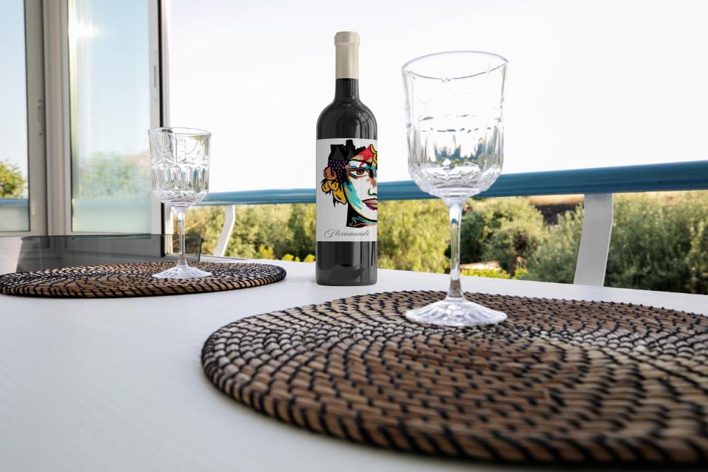 uma garrafa de vinho e dois copos numa mesa em Casa Floramundi em Catânia