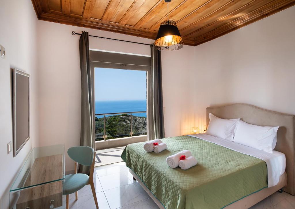 a bedroom with a bed and a large window at MELIKIRON LUXURY APARTMENTS in Agios Nikitas