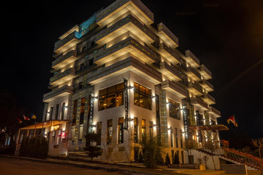 卡爾可夫的住宿－Готельно-ресторанний комплекс Каскад，一座高大的白色建筑,晚上有灯