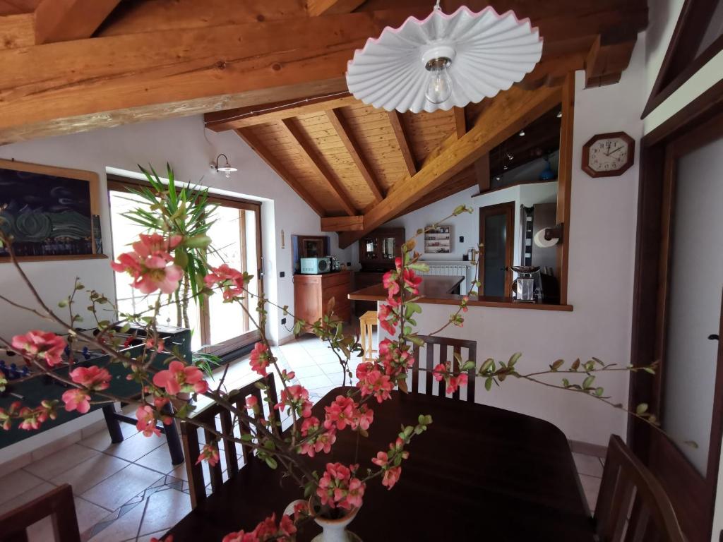 a dining room with a table with flowers on it at Chalet Lullaby in Fiumenero