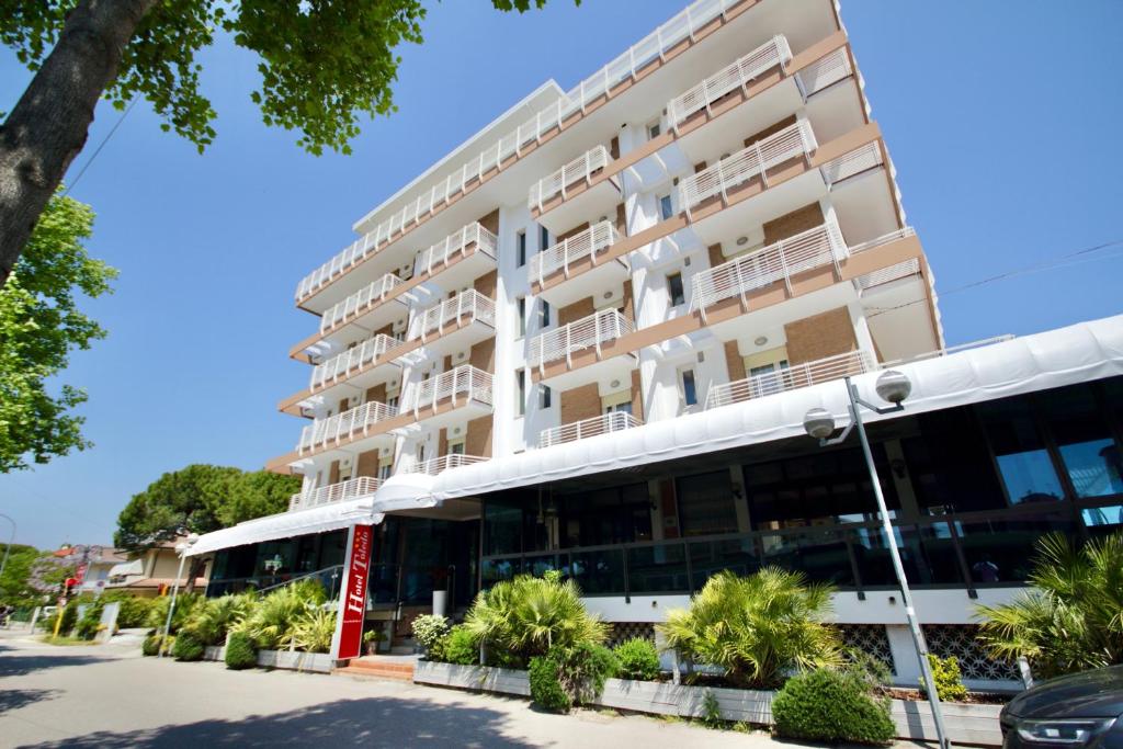 an apartment building in front of a parking lot at Hotel Toledo in Lido di Jesolo