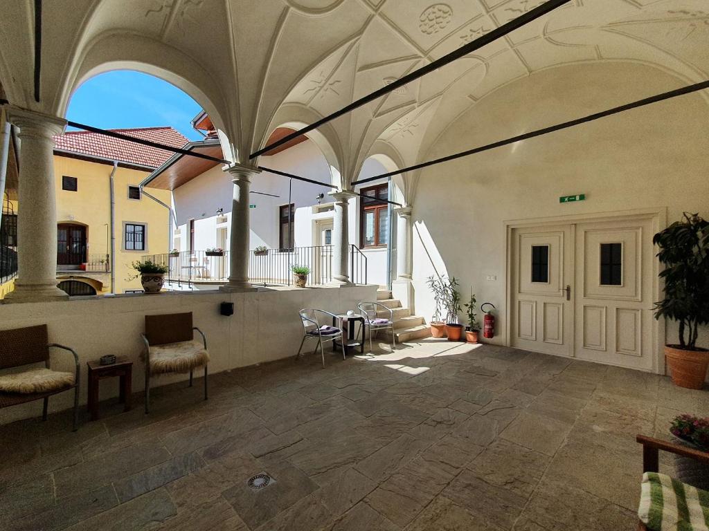 a large patio with chairs and a table in a building at apartmány LEVOČA in Levoča