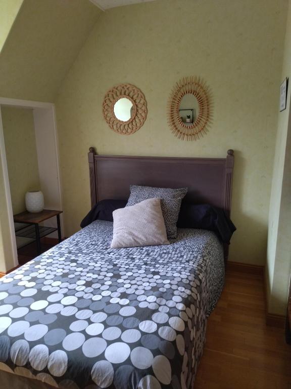 a bedroom with a bed and two mirrors on the wall at Chambre Solo Grande maison in Gouesnou